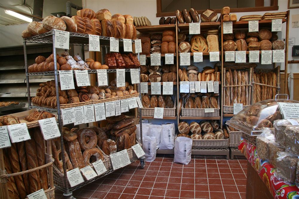 Bakery shelves stacked with loaves, each with a handwritten price tag