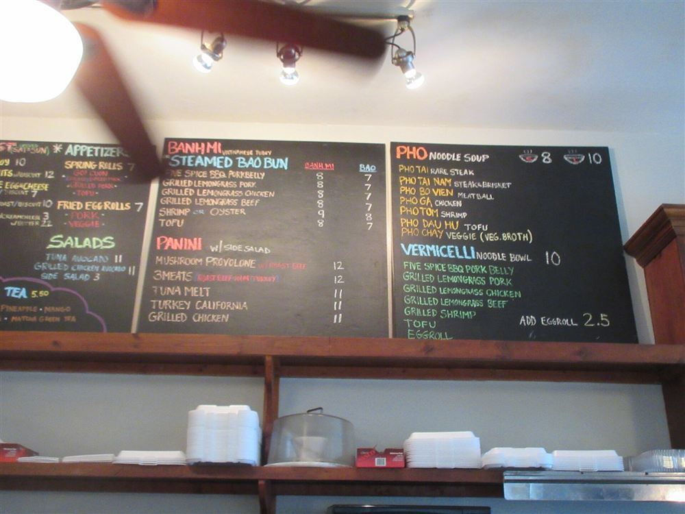 A café chalkboard listing dishes with their prices